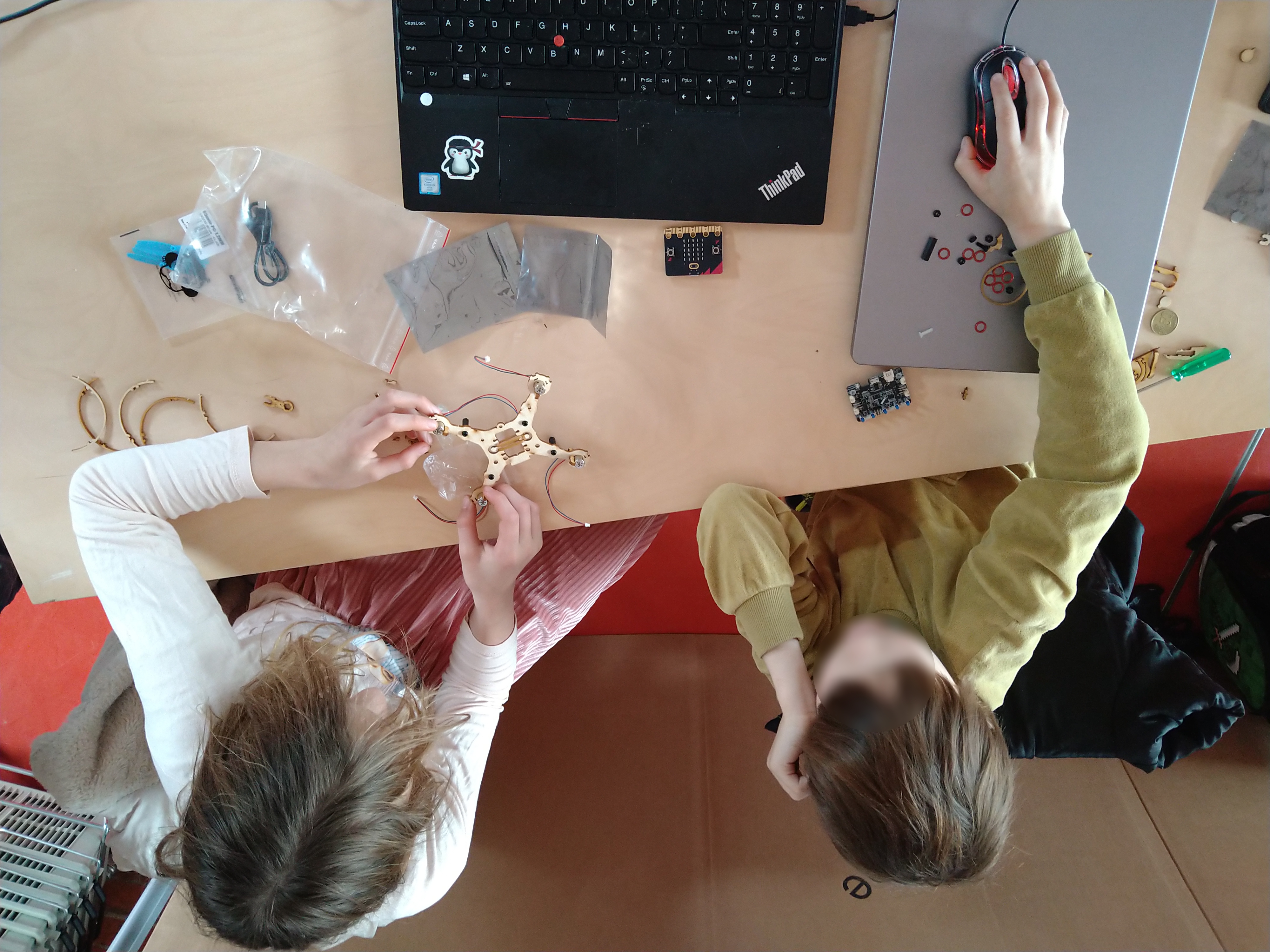 Ein Geschwisterpaar kooperiert beim Zusammenbauen der Air:bits.